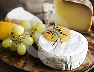 Variation of cheese and green grapes on a wooden platter food photography recipe idea