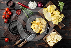 Variation different potato chips, on old dark  wooden table , top view flat lay
