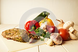 Variation of fresh and tasty vegetables and a lamb culotte on wooden table for dinner photo