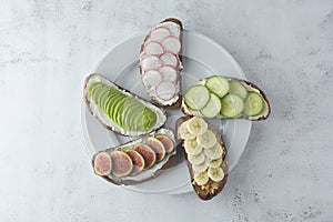 Variation of healthy breakfast sandwiches with avocado, cucumber, fig fruit, banana, cream cheese and wholegrain bread