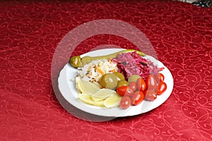 Variations of turshu, white cucumber, berries, white, red cabbage, green pepper.