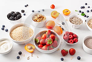 Variaty of raw cereals, fruits and nuts for breakfast. Oatmeal flakes and steel cut, barley, walnut, chia, apricot, strawberry.