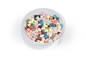 Varicolored jelly beans in bowl on a white background