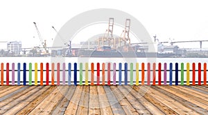 Varicolored wooden fence and floor wood with cargo ship backgro