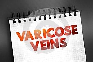 Varicose Veins - swollen and enlarged veins that usually occur on the legs and feet, text concept on notepad