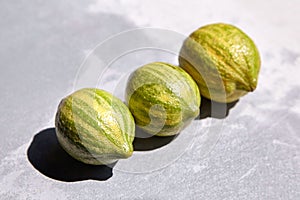 Variegated pink lemons or pink-fleshed Eureka lemons on gray concrete table. Whole citrus fruits with striped rind