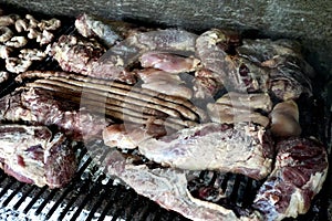 A Varierty of Meats cooking on a charcoal heated bbq.