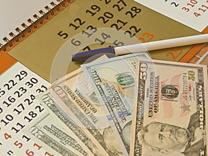 Variety of American money laid out under a stack of cash.Hundred US dollar bills. Selective focus.