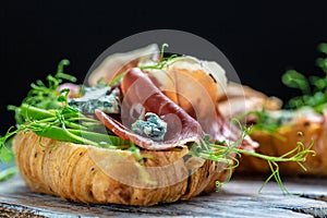 Variety of aperitifs Croissant sandwiches with jamon ham serrano paleta iberica, blue cheese, avocado, microgin on blue background