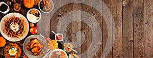 Variety of autumn breakfast or brunch items. Corner border against a dark wood banner background with copy space.