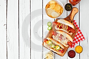 Variety of BBQ hot dogs, above view over a white wood background with copy space