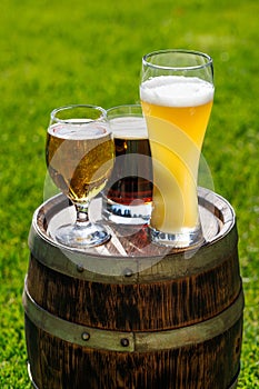 Variety of beer glasses on rustic wooden barrel