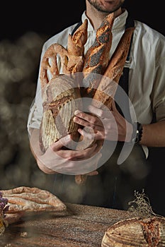 Variety of bread hold men`s hands