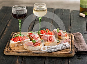 Variety of bruschetta with glass of red and white wine