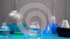 Variety of chemical flasks and medical glass containers with colored liquids