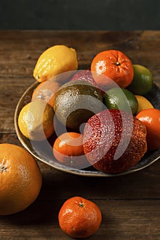 A variety of citrus fruits on the bowl, rustic still life