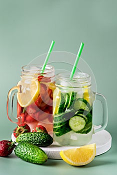 Variety of Cold Summer Drinks in Glass Jars Infused Detox Water with Cucumber Lemon and Strawberry Healthy Drink Green Background