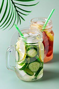 Variety of Cold Summer Drinks in Glass Jars Infused Detox Water with Cucumber Lemon and Strawberry Healthy Drink Green Background