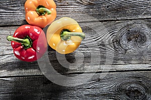 Variety of colorful bell peppers on authentic old wood