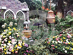 Variety of colorful flowers, leafs and trees in a sprawling garden outside a house on a sunny day