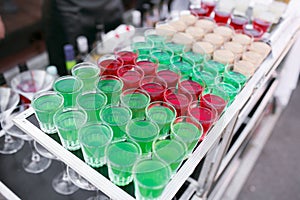 Variety of colorful green red and white beautiful alcohol sweet shooters shots cocktail fresh beverage in small glasses