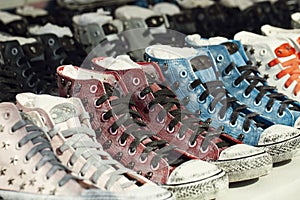 Variety of the colorful sneaker shoes , cool youth colorful gym shoes standing in row on white background, side view.