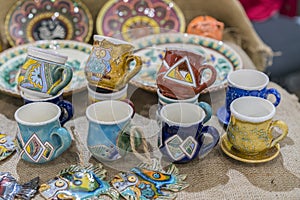 Variety of Colorfully Painted Ceramic Pots in an Outdoor Shopping Market. pottery in the shop window. Clay cups and plates