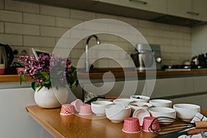 Variety of cupcake liners in different colors with a muffin pan and wire whisk.