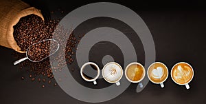 Variety of cups of coffee and coffee beans in burlap sack on black background