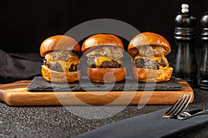 Variety of delicious cheeseburgers arranged on a wooden board
