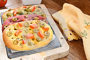 Variety of different focaccia, with pumpkin, carrot and beet, on a rustic table