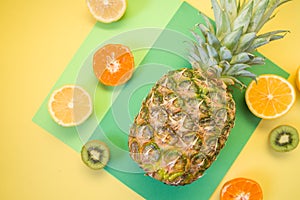 Variety of Different Tropical Seasonal Summer Fruits. Citrus Orange Pineapple Lemons on Overlapping Paper in Trendy Pastel Colors: