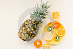 Variety of Different Tropical Seasonal Summer Fruits. Citrus Oranges Pineapple Lemons on White Background with pastel yellow trend