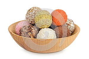 A variety of different truffles in a wooden bowl Isolated on a white background