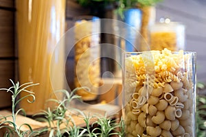 Variety of dry pasta macaroni,fusilli,shapes of Italian pasta in glass jars,set of many different pasta types,short hollow fluted