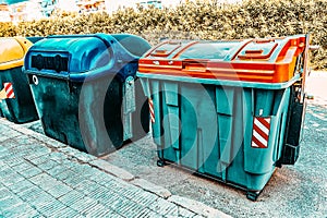 Variety dumpstersrecycling containers  on a city street