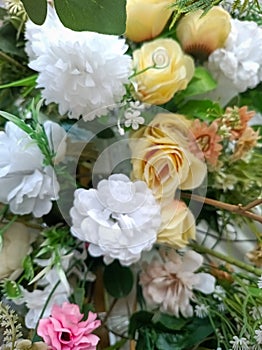 A variety of fake flowers are used to decorate the wedding reception room. lily, rose, tulip etc