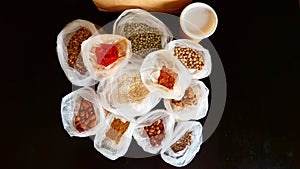 Variety of foodstuffs in open paper bags, including spices and seasonings