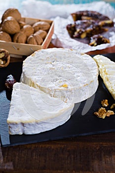 French soft cheeses - camembert, marcaire, munster, brie - delicious dessert with nuts and dried fruits