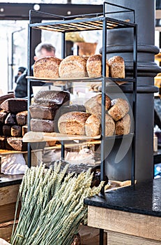 Variety of fresh baked artisan bread on a shelf in bakery shop. Gourmet breads for sale