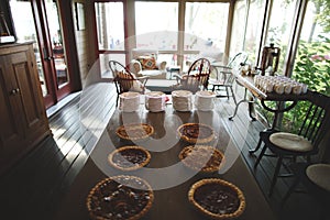 Variety of freshly made pies lined up on a kitchen table in a residential home
