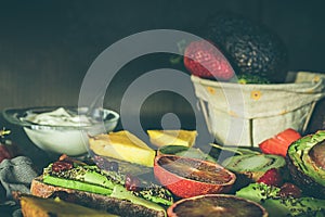 Variety of fruits, avocado, blood oranges, pineapple, kiwi, strawberries and grapes.