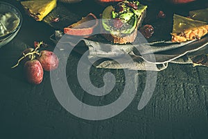 Variety of fruits, avocado, blood oranges, pineapple, kiwi, strawberries and grapes.