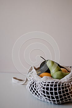 Variety of fruits in eco aware bag are lying on the table