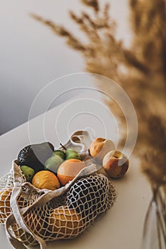 Variety of fruits in eco aware bag are lying on the table