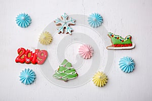 Variety of gingerbreads and meringue on a white vintage background, flat lay, top view. Holiday sweets. New Year and Christmas the