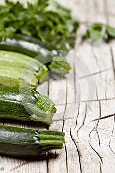 Variety of green organic vegetables on rustic wooden background