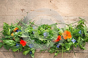 Variety of Herbs and Edible Flowers on Wooden Background