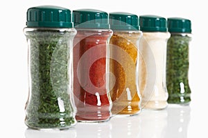 Variety of herbs and spices in glass jar on white background