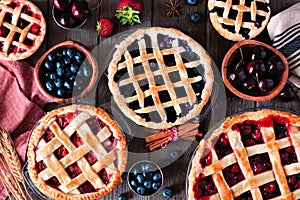 Variety of homemade fruit pies. Top view table scene over rustic wood.